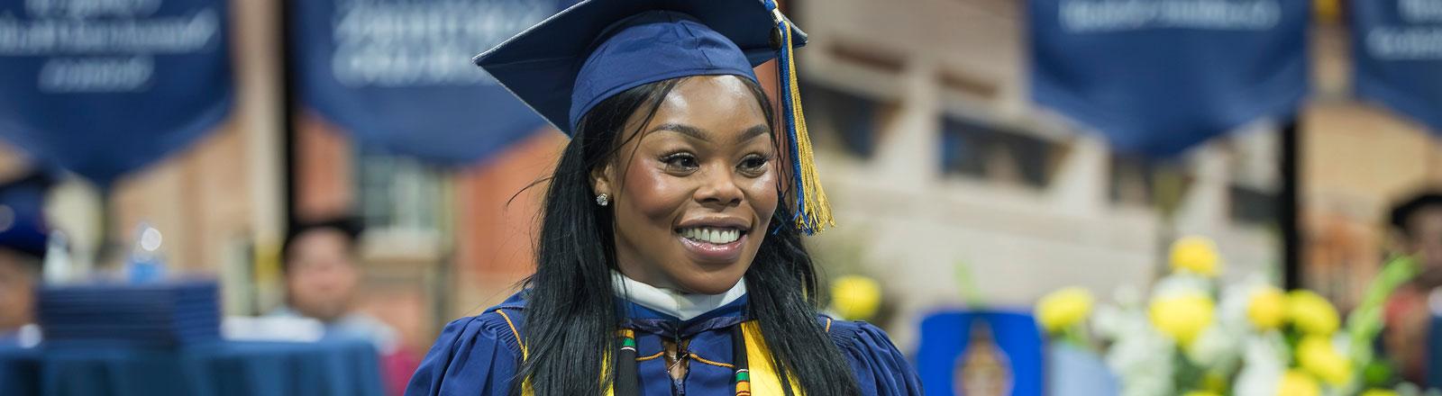 Graduating doctoral student looking out at audience at commencement cereomny